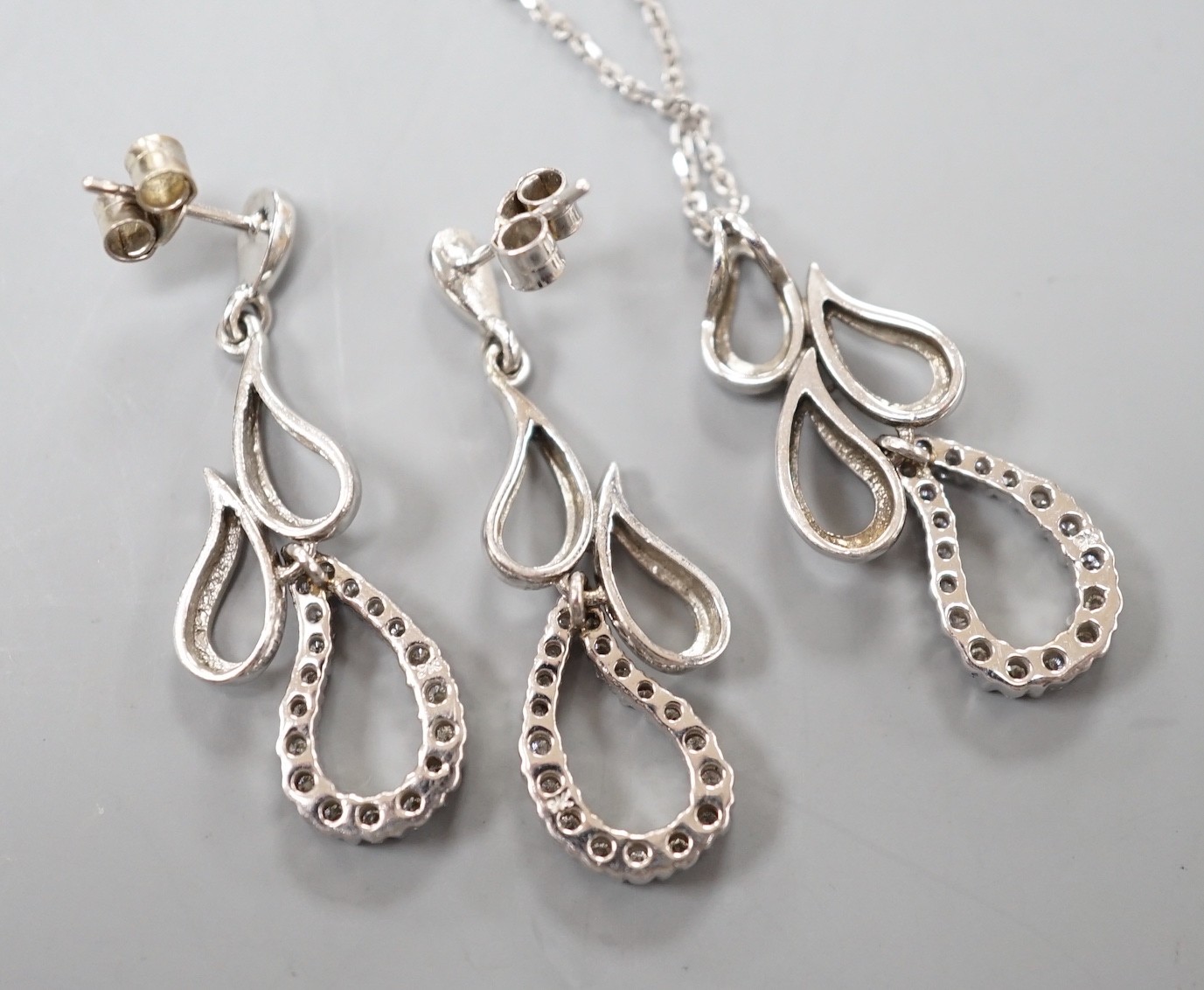 A modern white metal and diamond set quadruple teardrop shaped cluster drop pendant, 28mm, on a 9ct white gold fine link chain, 39cm and a pair of matching earrings, gross weight 7.6 grams.